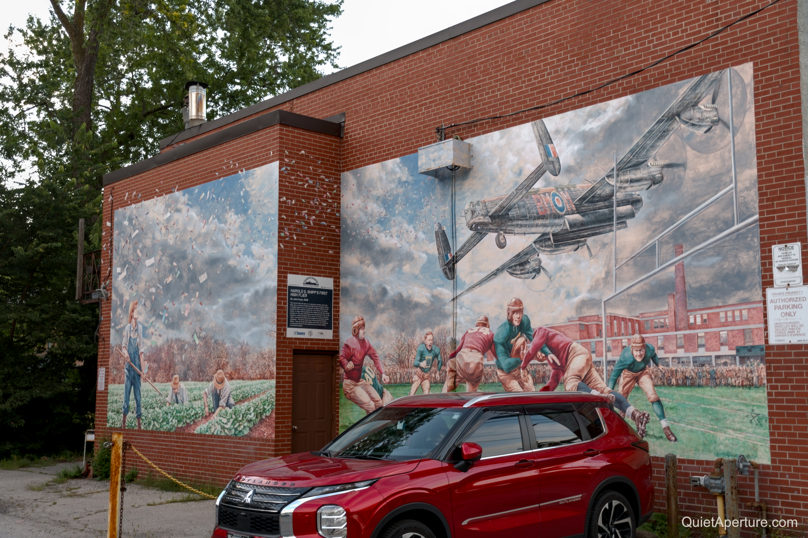 Industrial history murals painted across a red-brick building, frame 03.